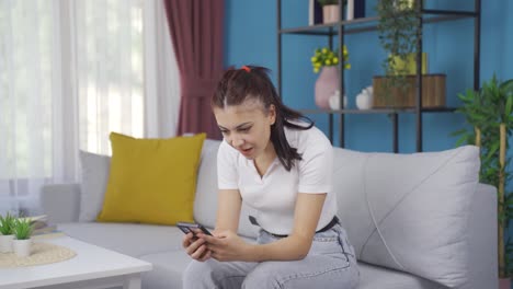Young-woman-laughing-at-phone-message.
